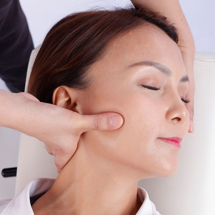 Karada therapist aligning a client's neck